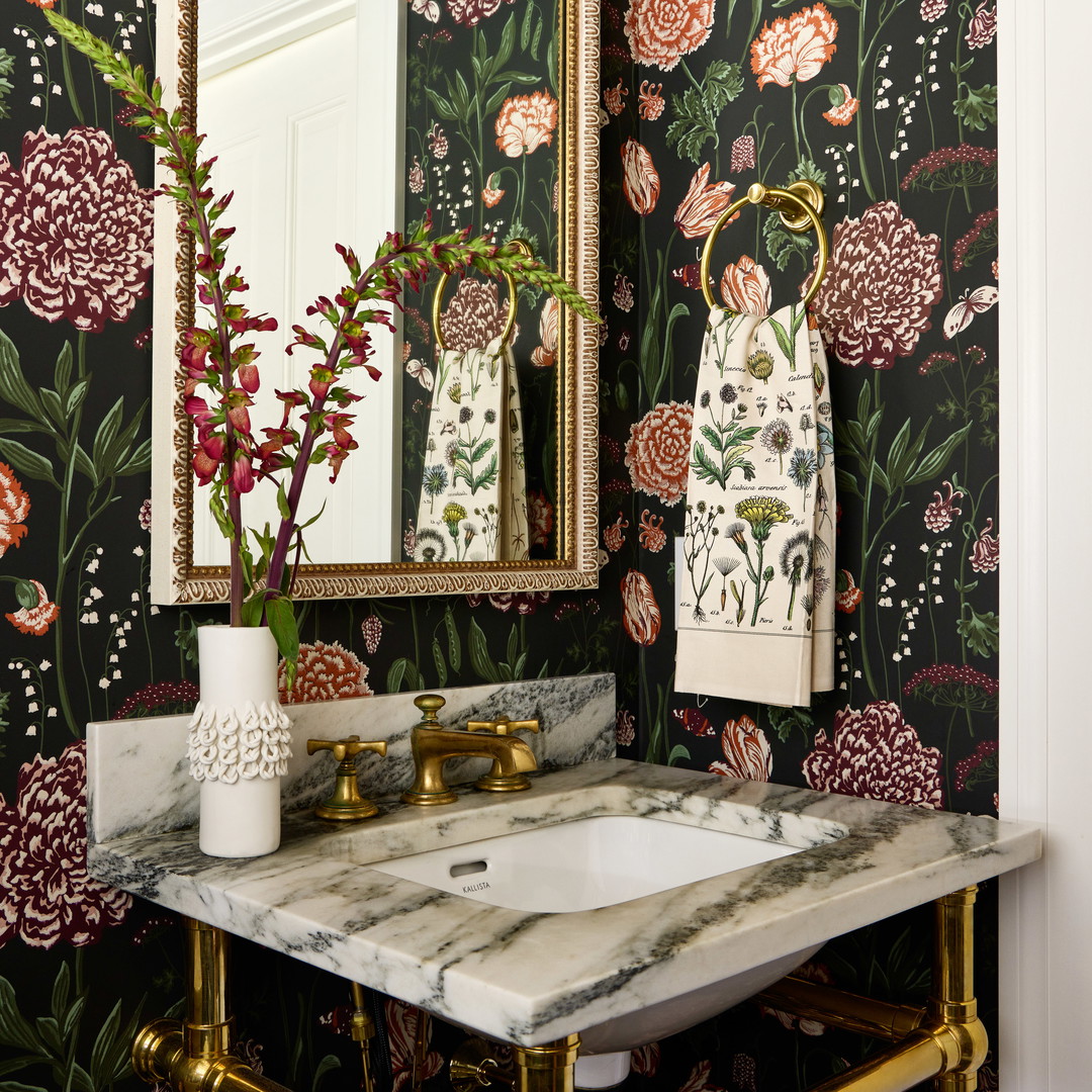 a bathroom with a sink, mirror and flowers on the wall