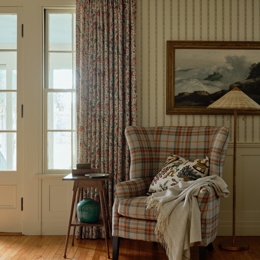 a living room with a chair and a painting on the wall