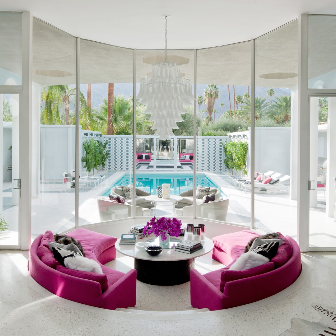 a living room filled with furniture next to a swimming pool