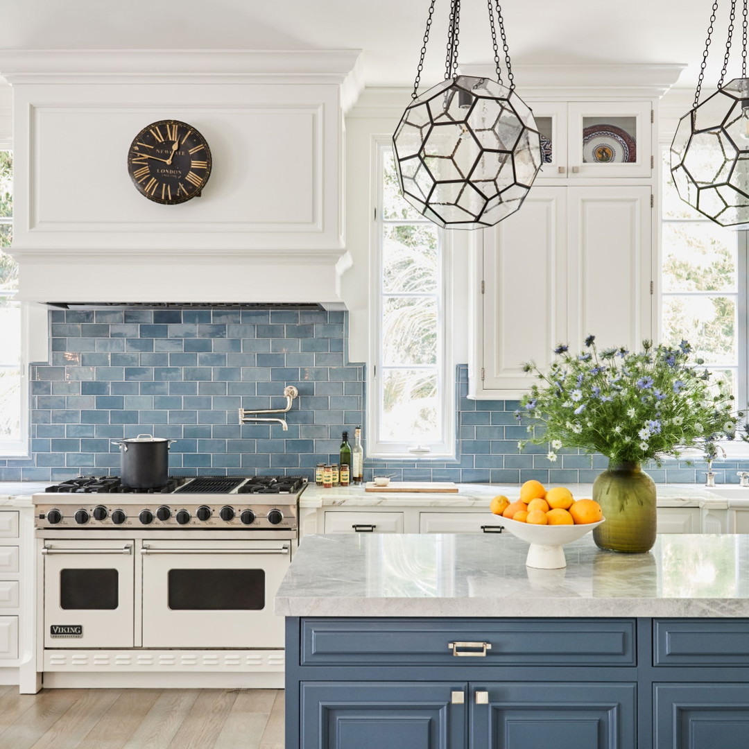 a kitchen with blue and white cabinets and a clock on the wall