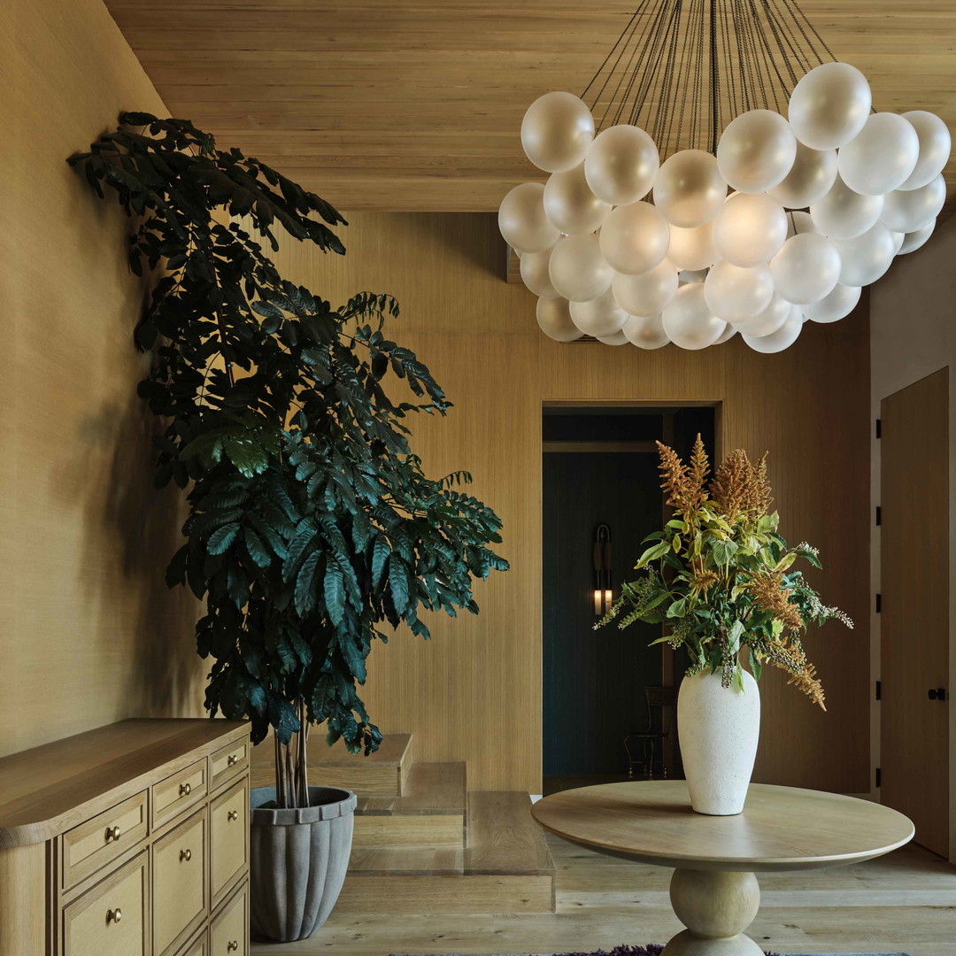 a living room with a table and a potted plant