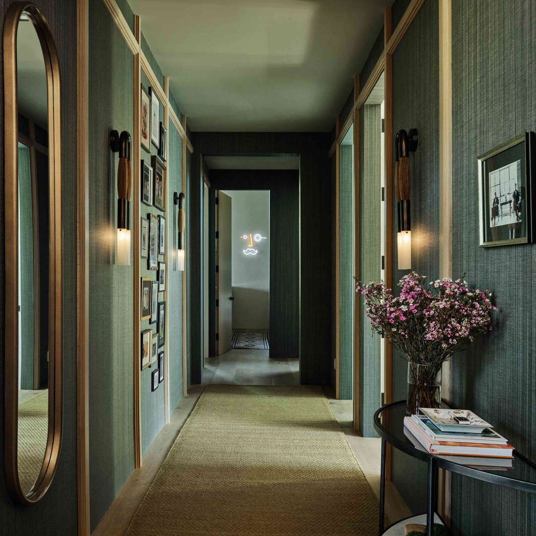 a long hallway with a vase of flowers on a table