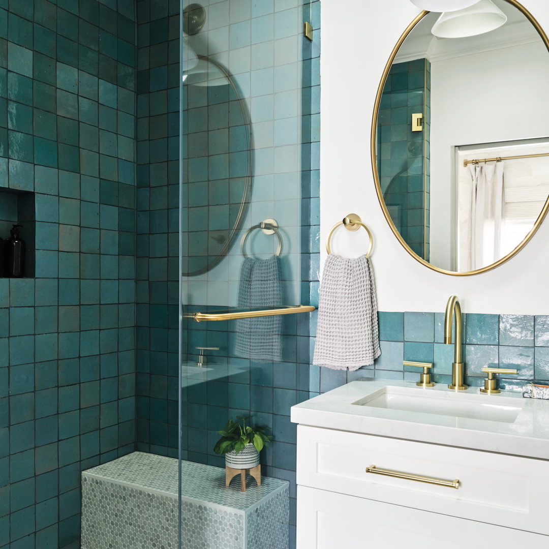 a bathroom with a shower, sink and mirror