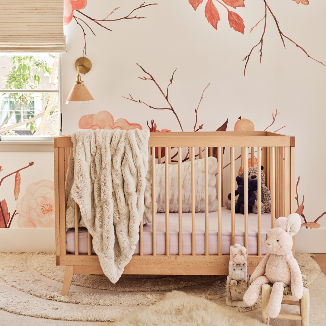 a baby's room with a floral wallpaper and a wooden crib