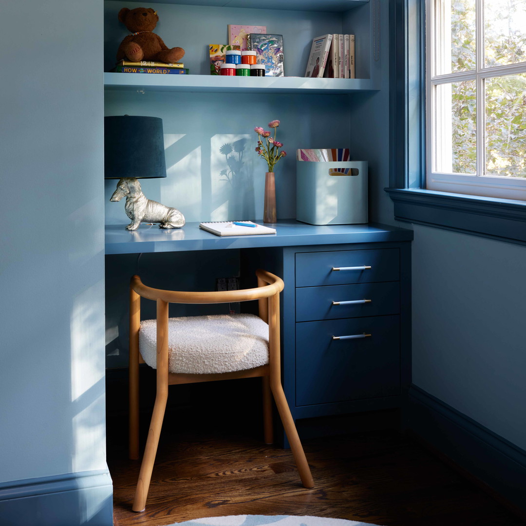 a blue room with a desk and a chair