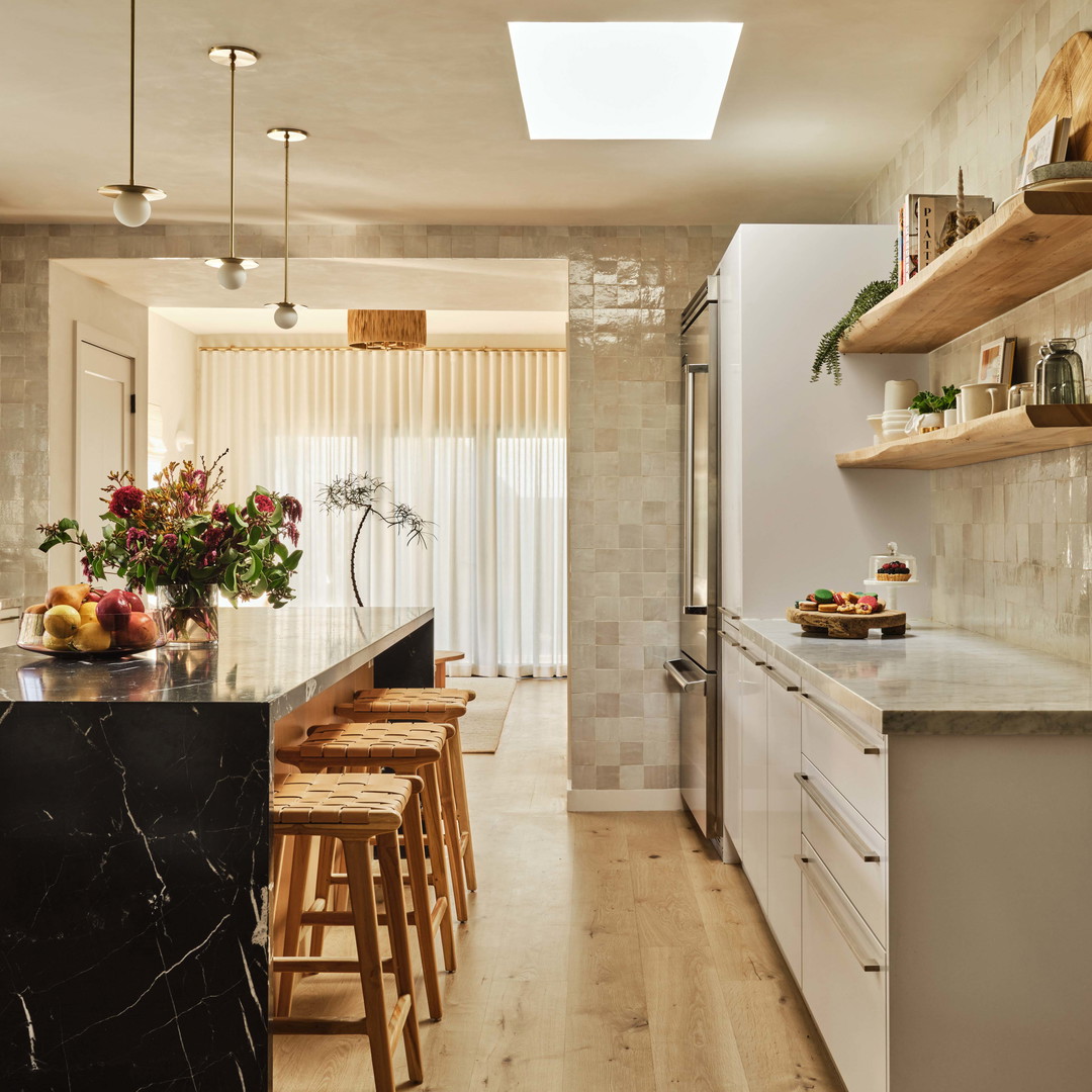 a kitchen with a marble counter top and wooden stools
