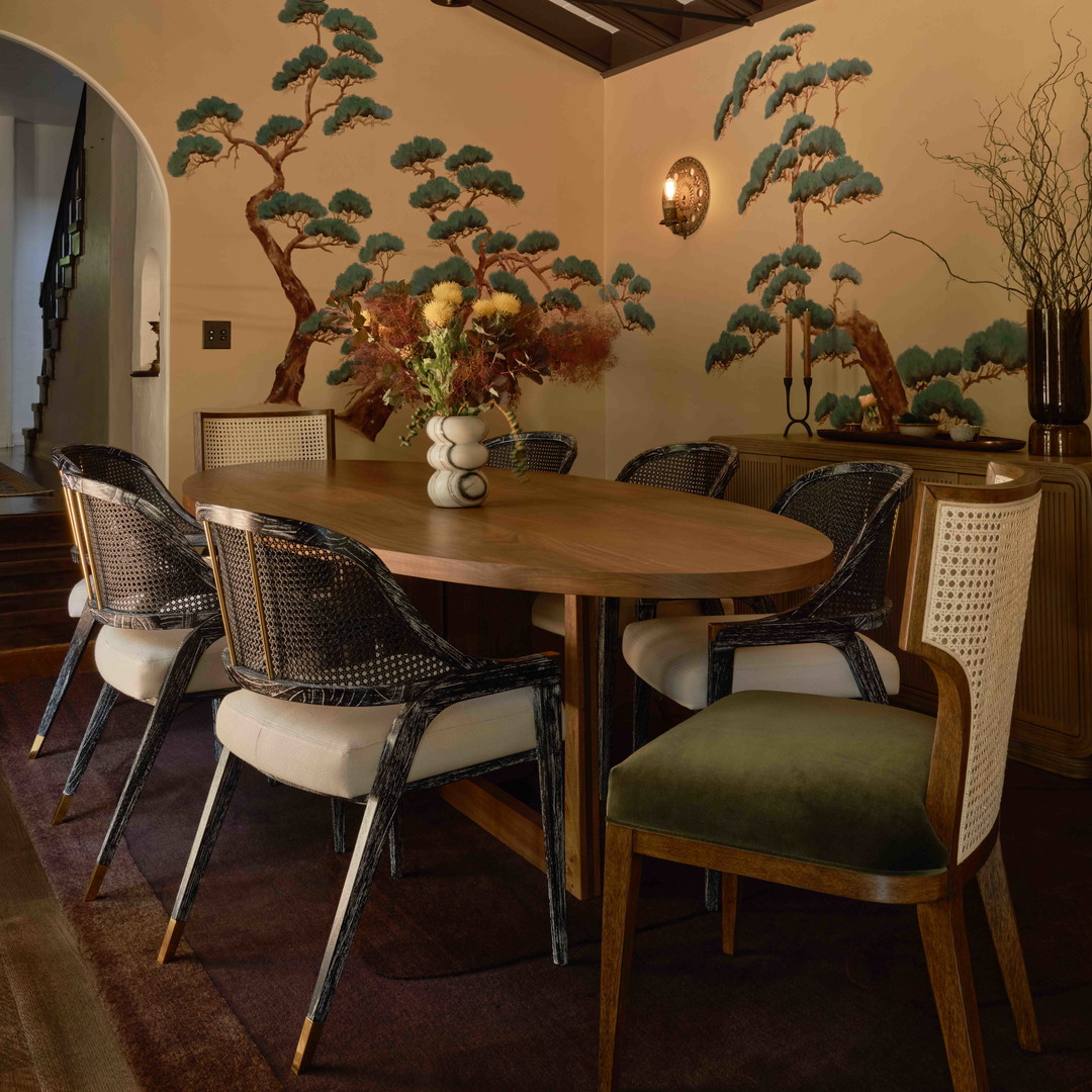 a dining room table with chairs and a vase of flowers