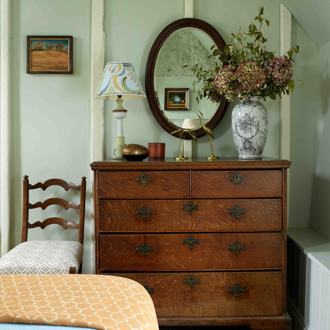 a bedroom with a dresser and a mirror