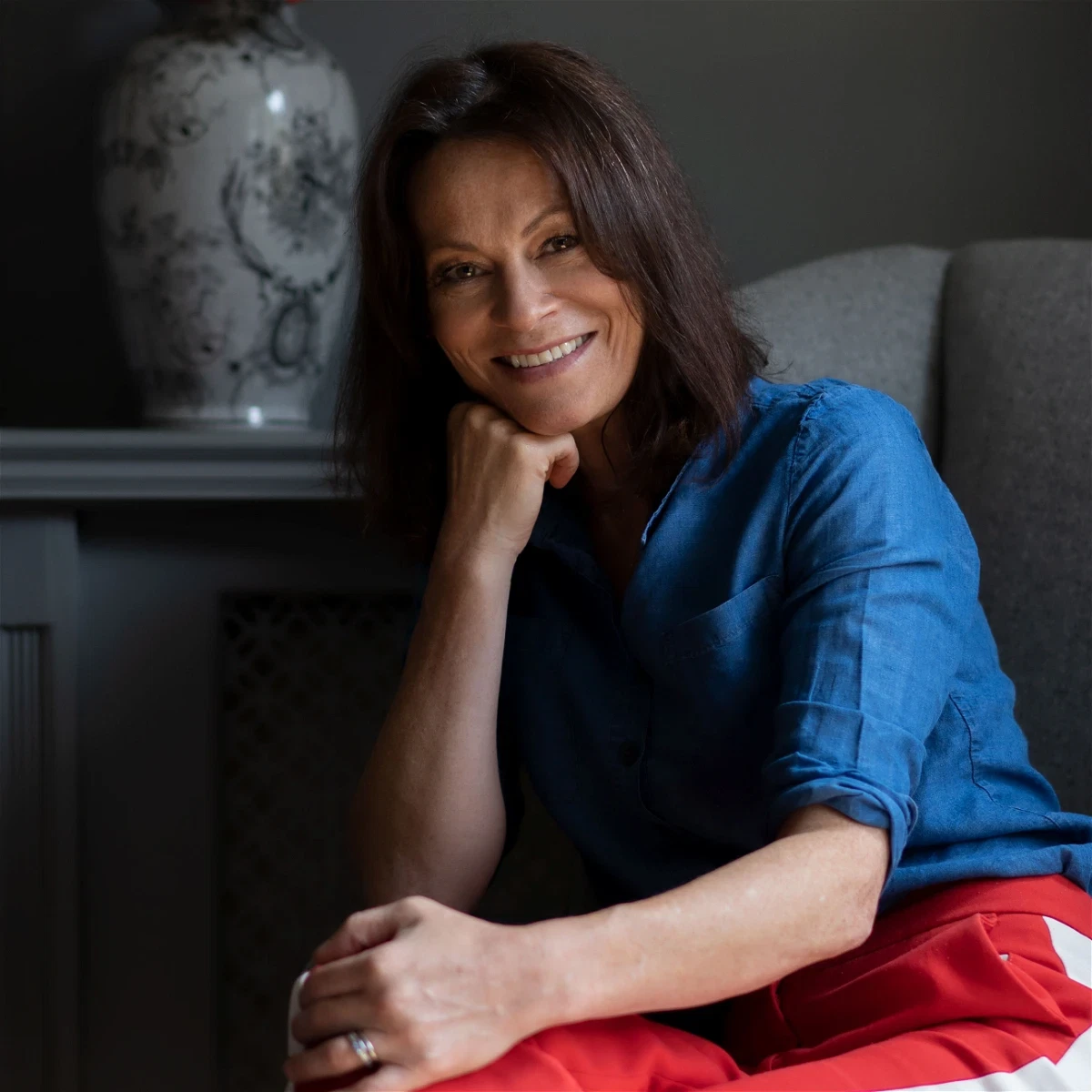 a woman sitting on a couch smiling at the camera