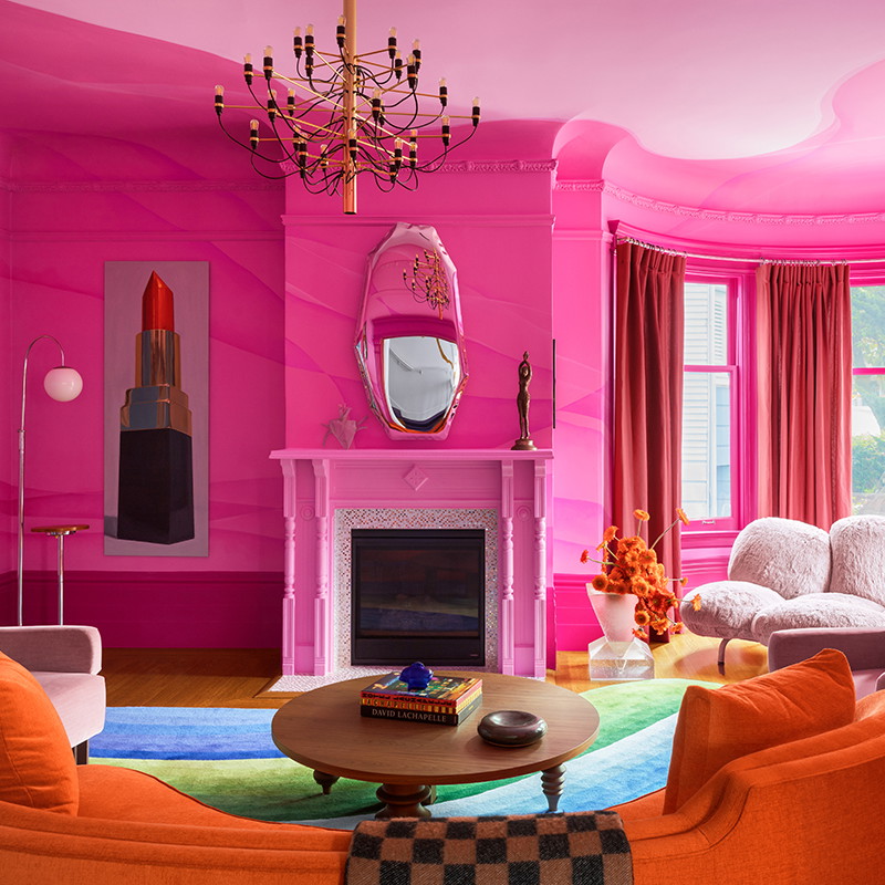 a living room with pink walls and furniture