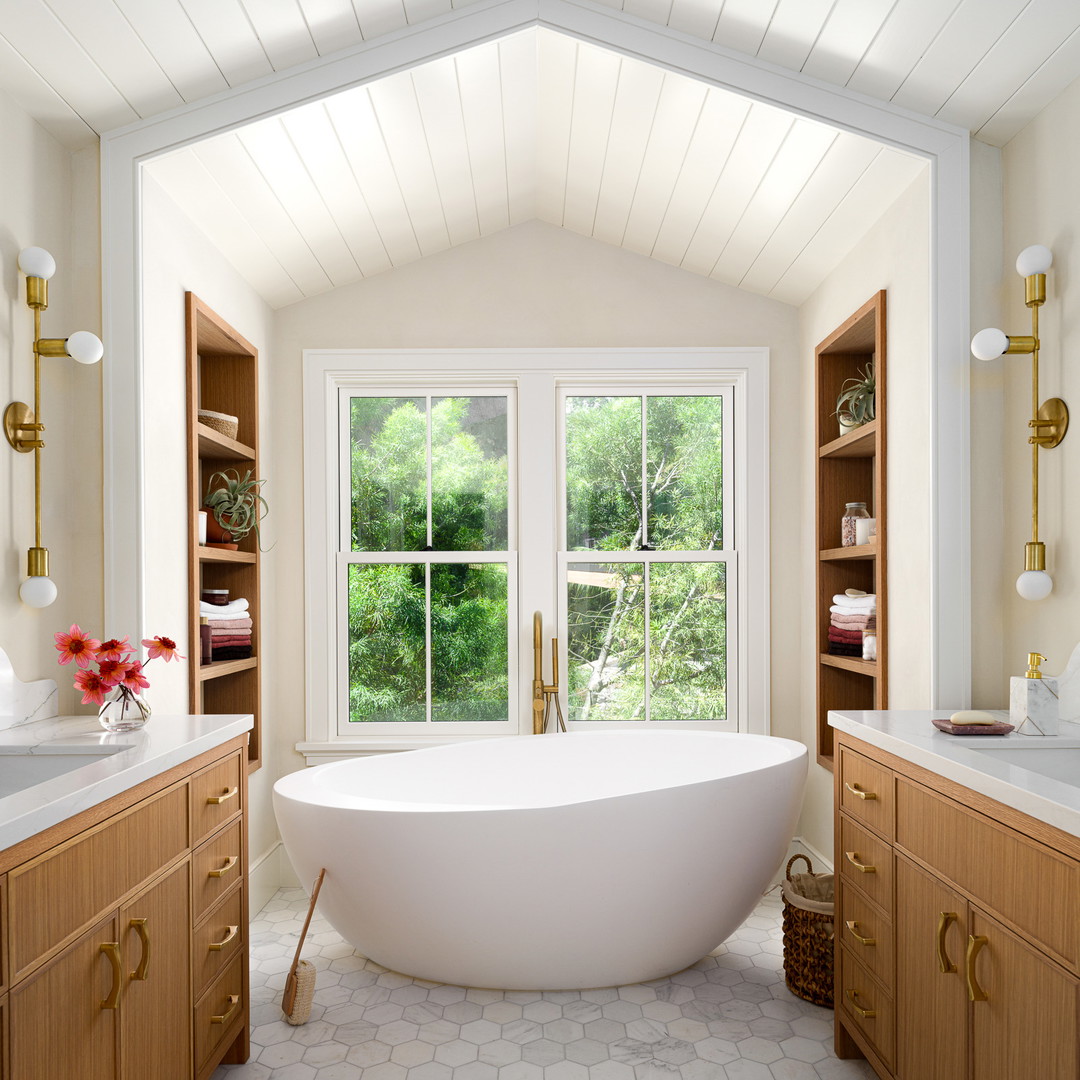 a large white bath tub sitting in a bathroom next to a window