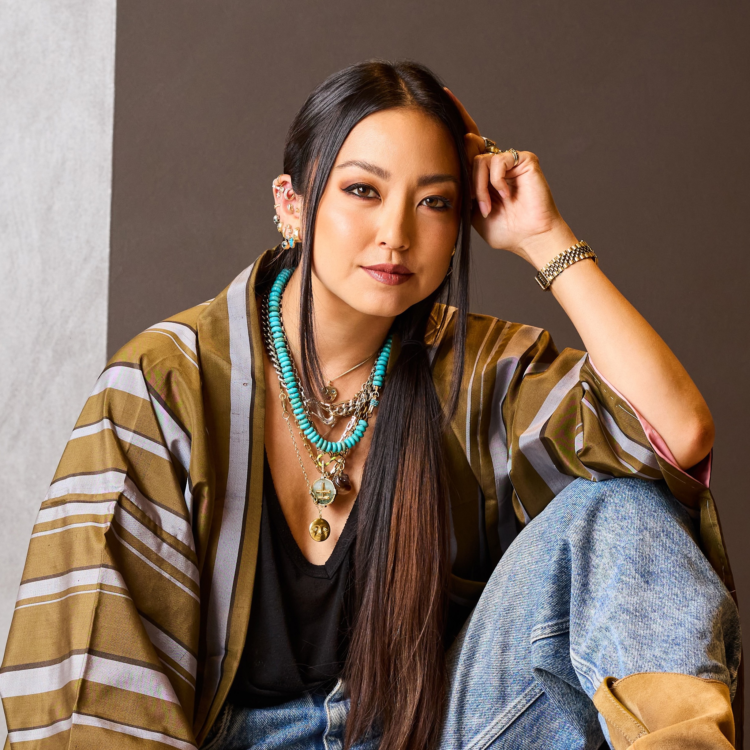 a woman sitting on the floor wearing a necklace