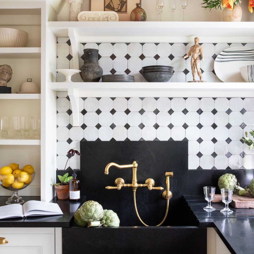 a black and white tiled kitchen with brass faucet