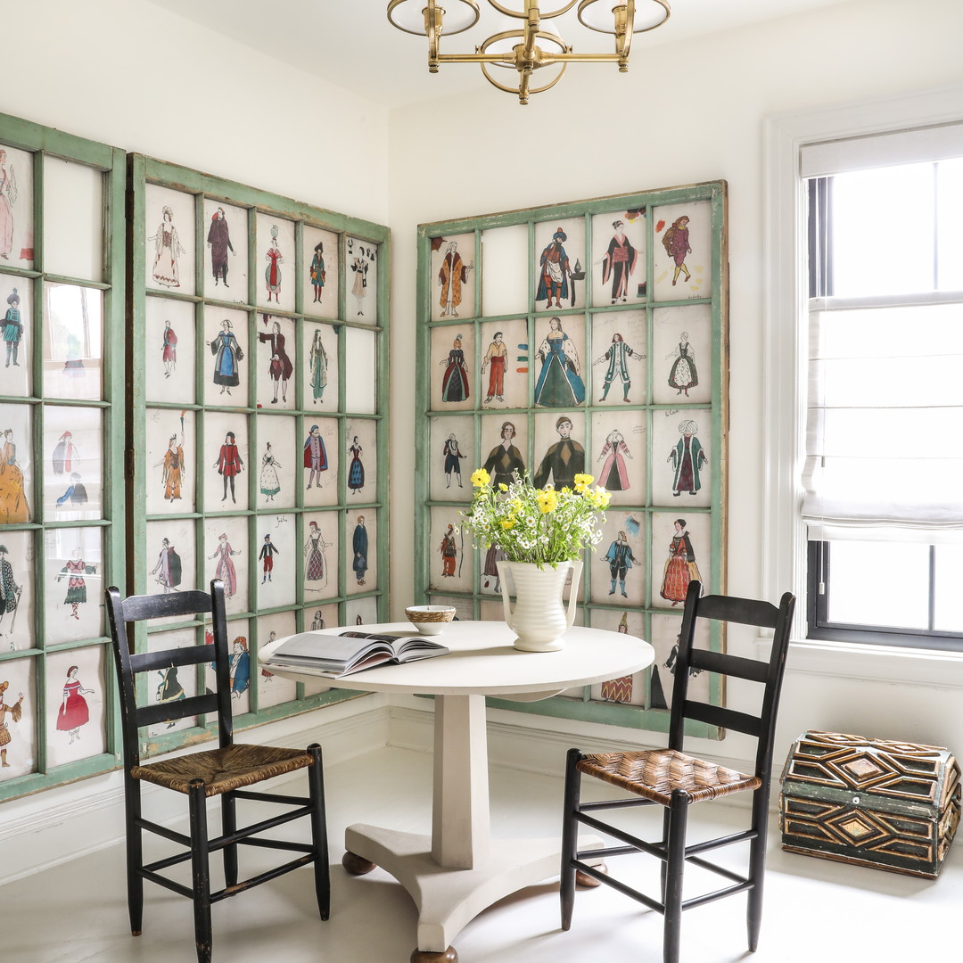 a room with a table, chairs, and pictures on the wall