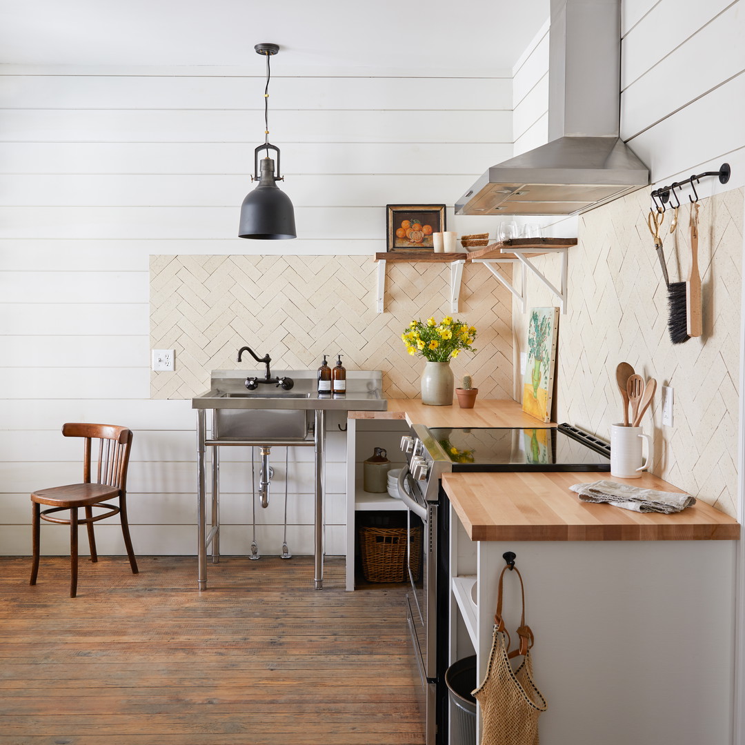 a kitchen with a sink, stove, and a stove top oven