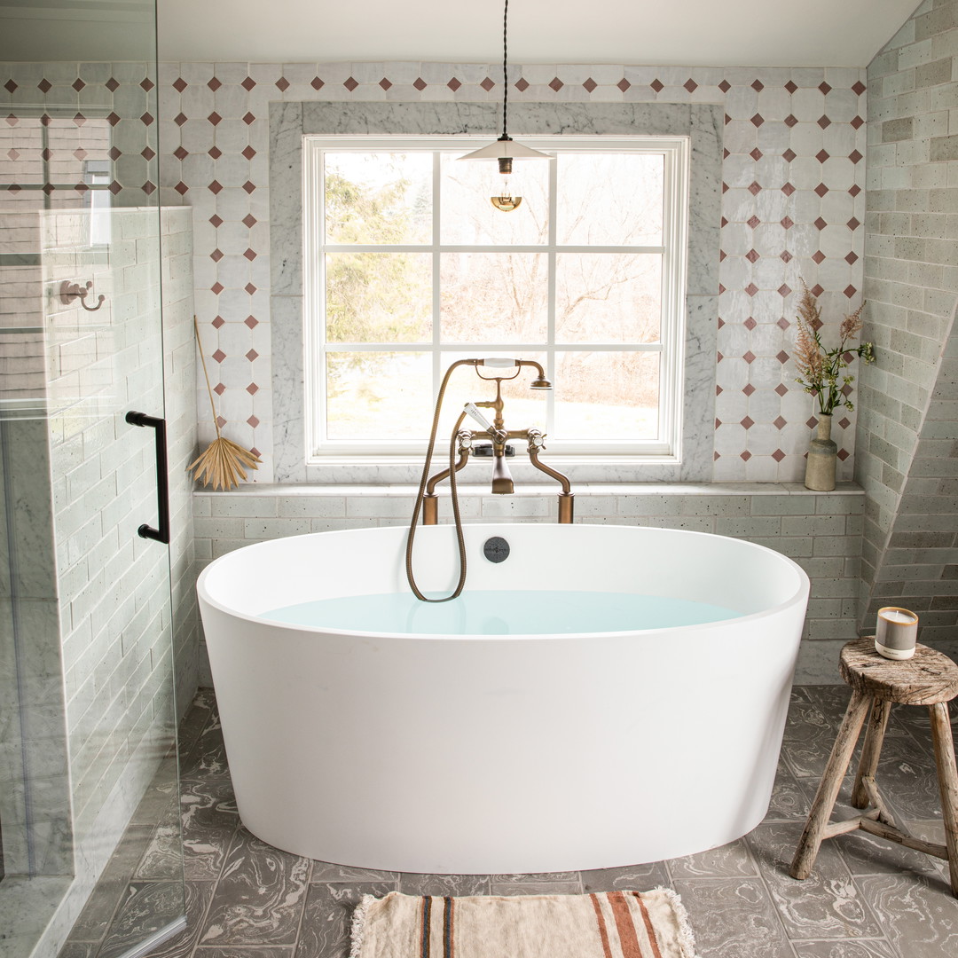 a bathtub in a bathroom with a rug on the floor