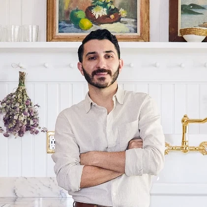 a man standing in a kitchen next to a stove top oven