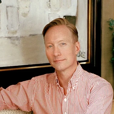 a man sitting on a couch in front of a painting