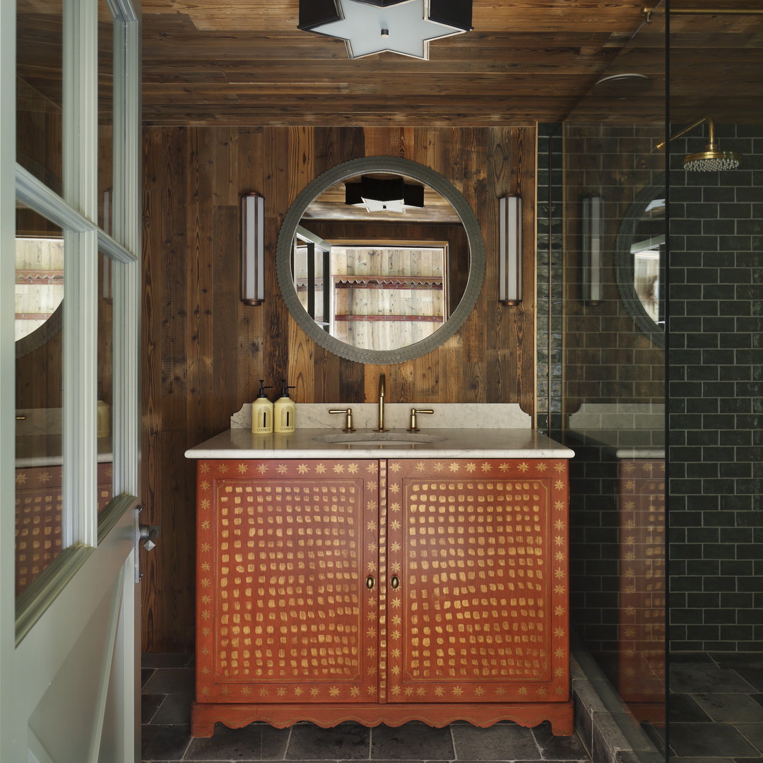 a bathroom with a wooden cabinet and a round mirror