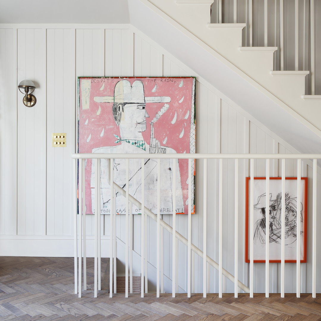 a white staircase with a painting on the wall