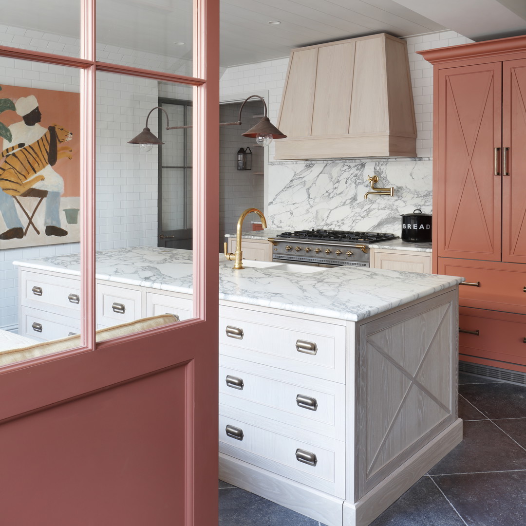 a kitchen with marble counter tops and pink cabinets