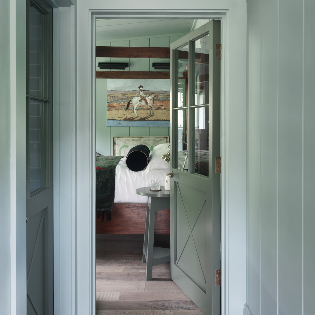 a hallway leading to a bedroom with a painting on the wall