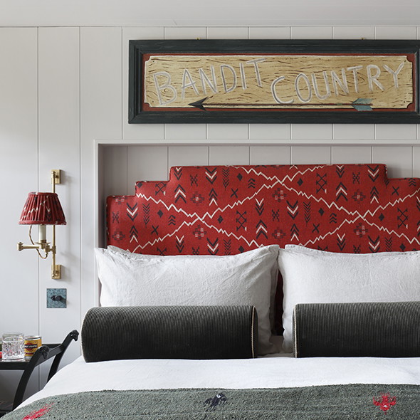 a bed with a red headboard and two lamps