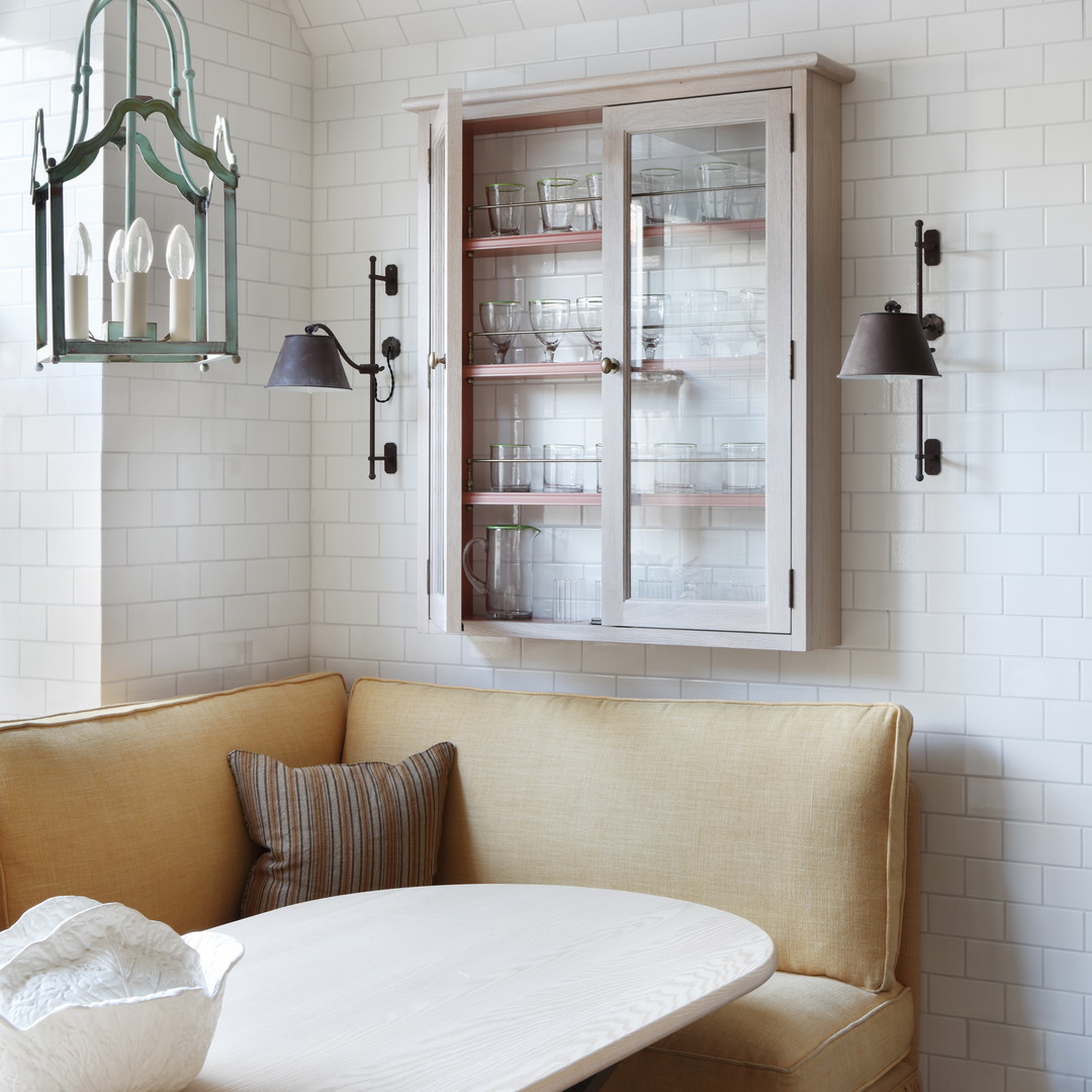 a corner table with a bench in front of a window