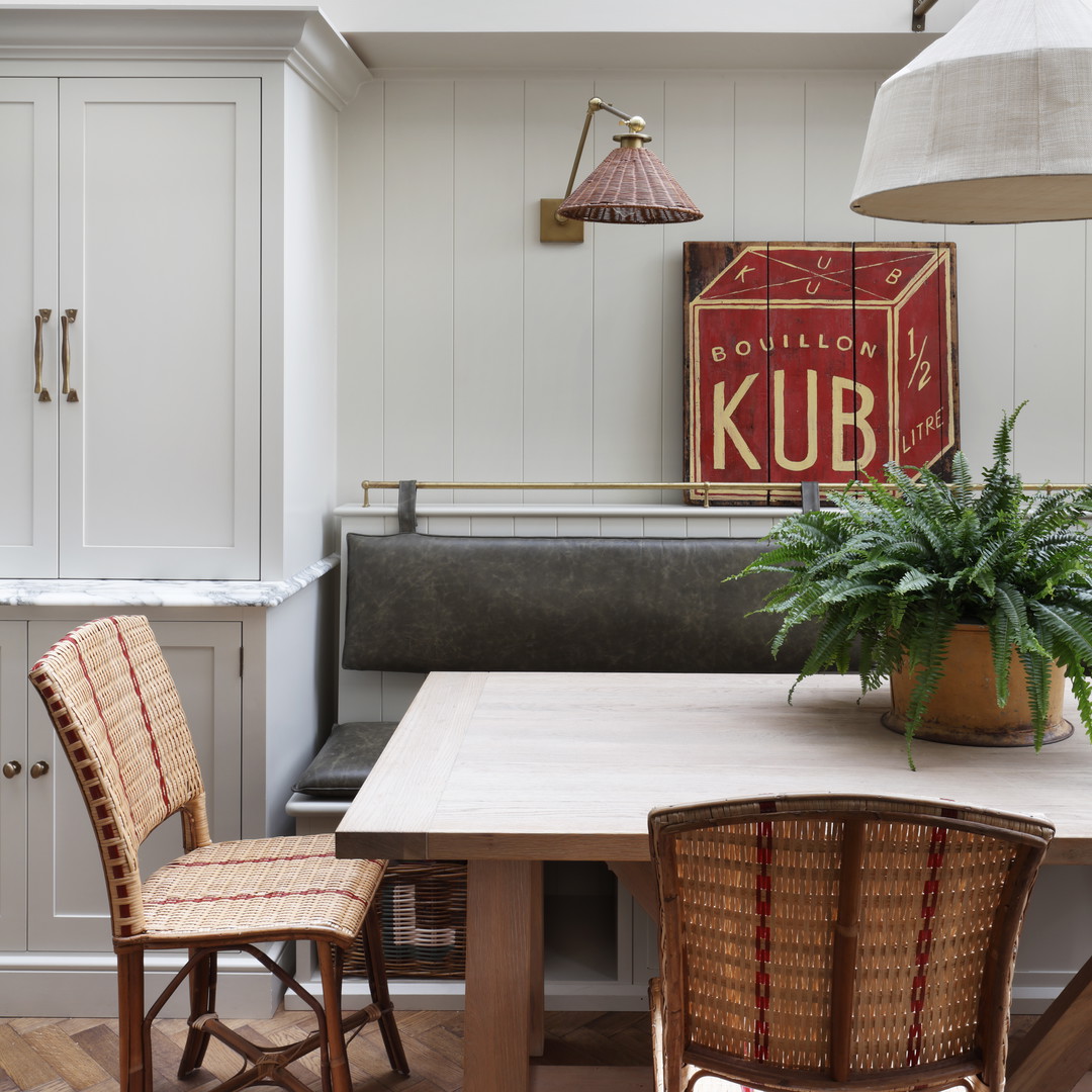 a kitchen with a table and chairs and a potted plant