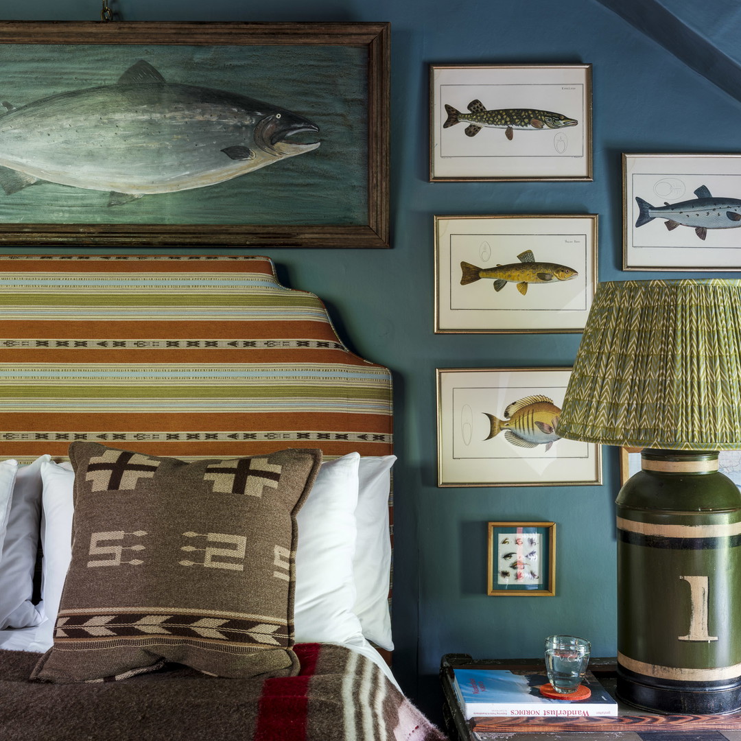 a bed room with a neatly made bed and pictures on the wall