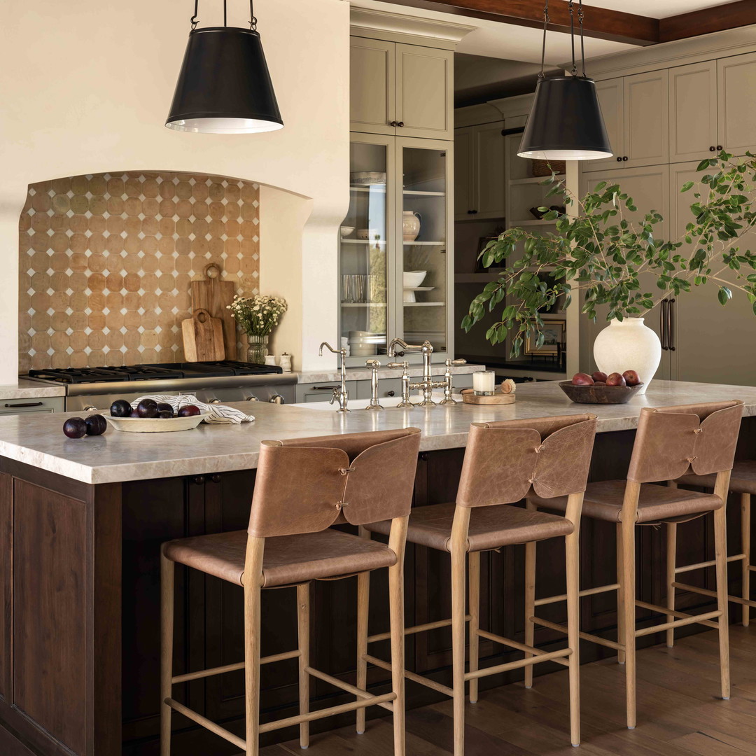 a large kitchen with a center island and wooden chairs