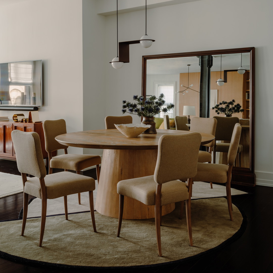 a dining room with a round table and chairs