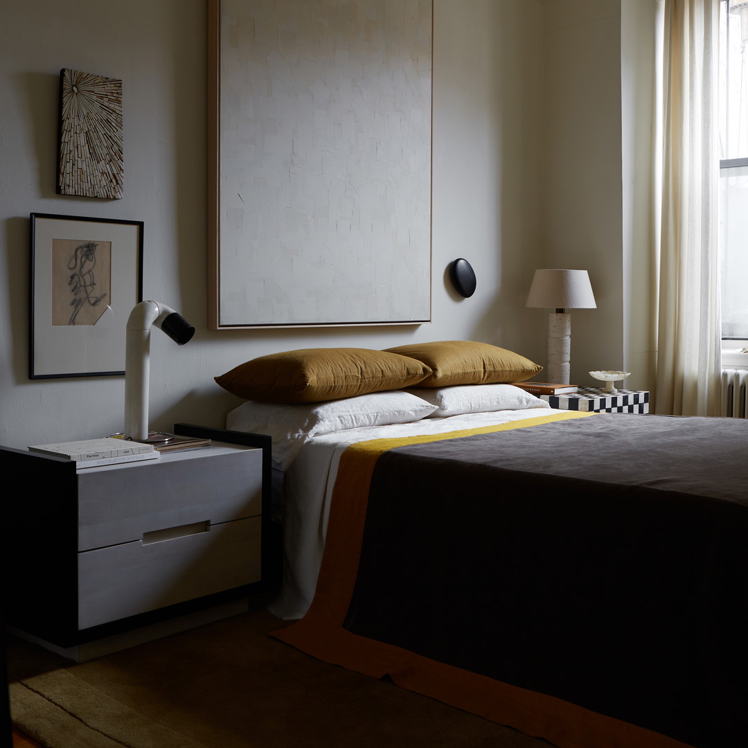 a bed sitting in a bedroom next to a window