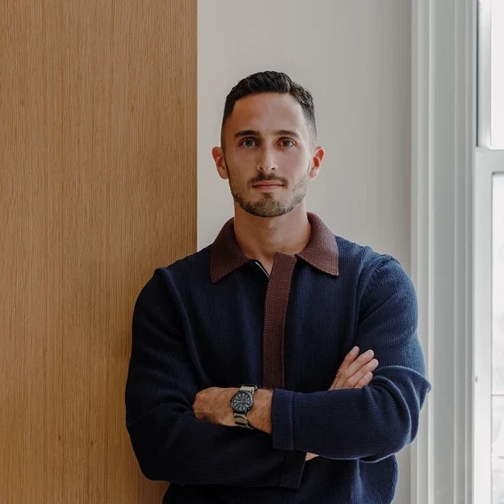 a man leaning against a wall with his arms crossed