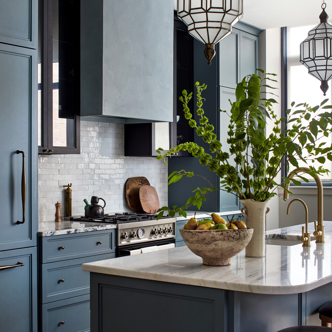 a kitchen with blue cabinets and a marble island