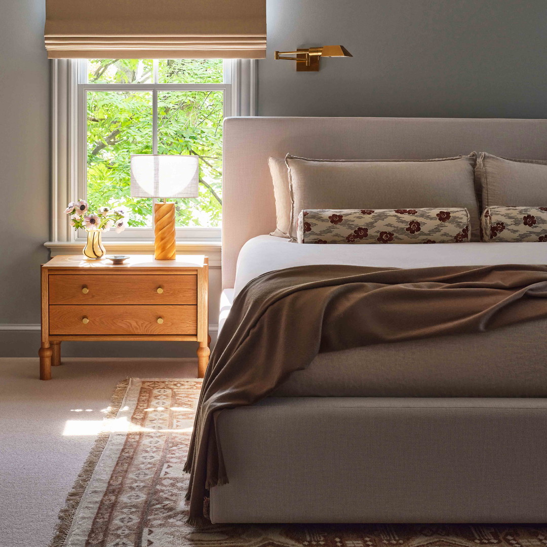 a bedroom with a bed, dresser and window