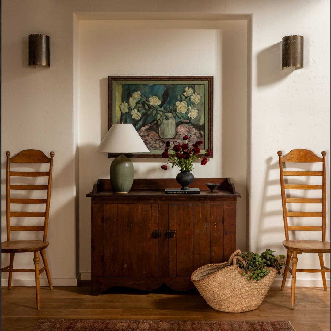 a room with two chairs, a table and a painting on the wall