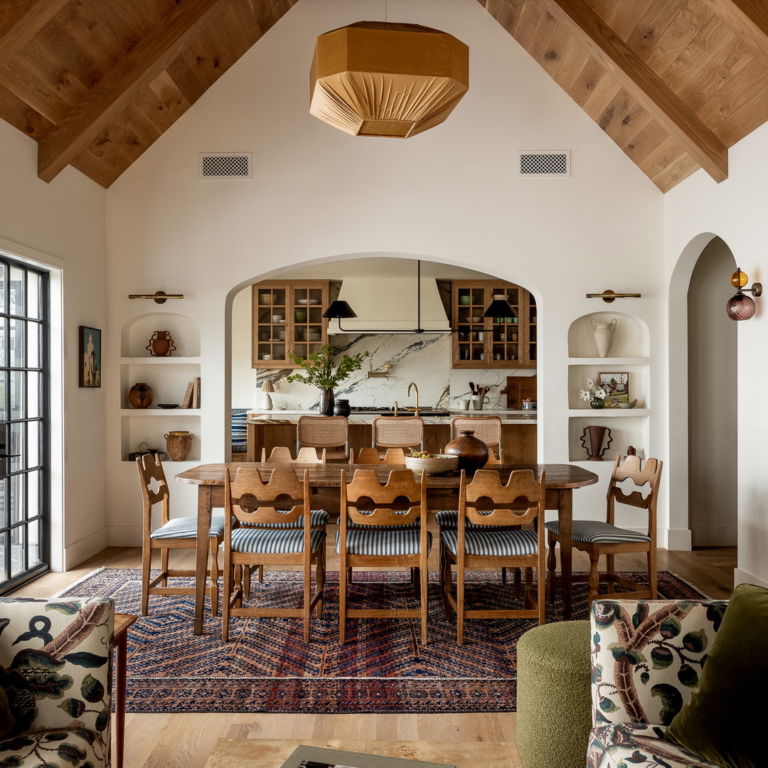 a dining room with a large wooden table surrounded by chairs