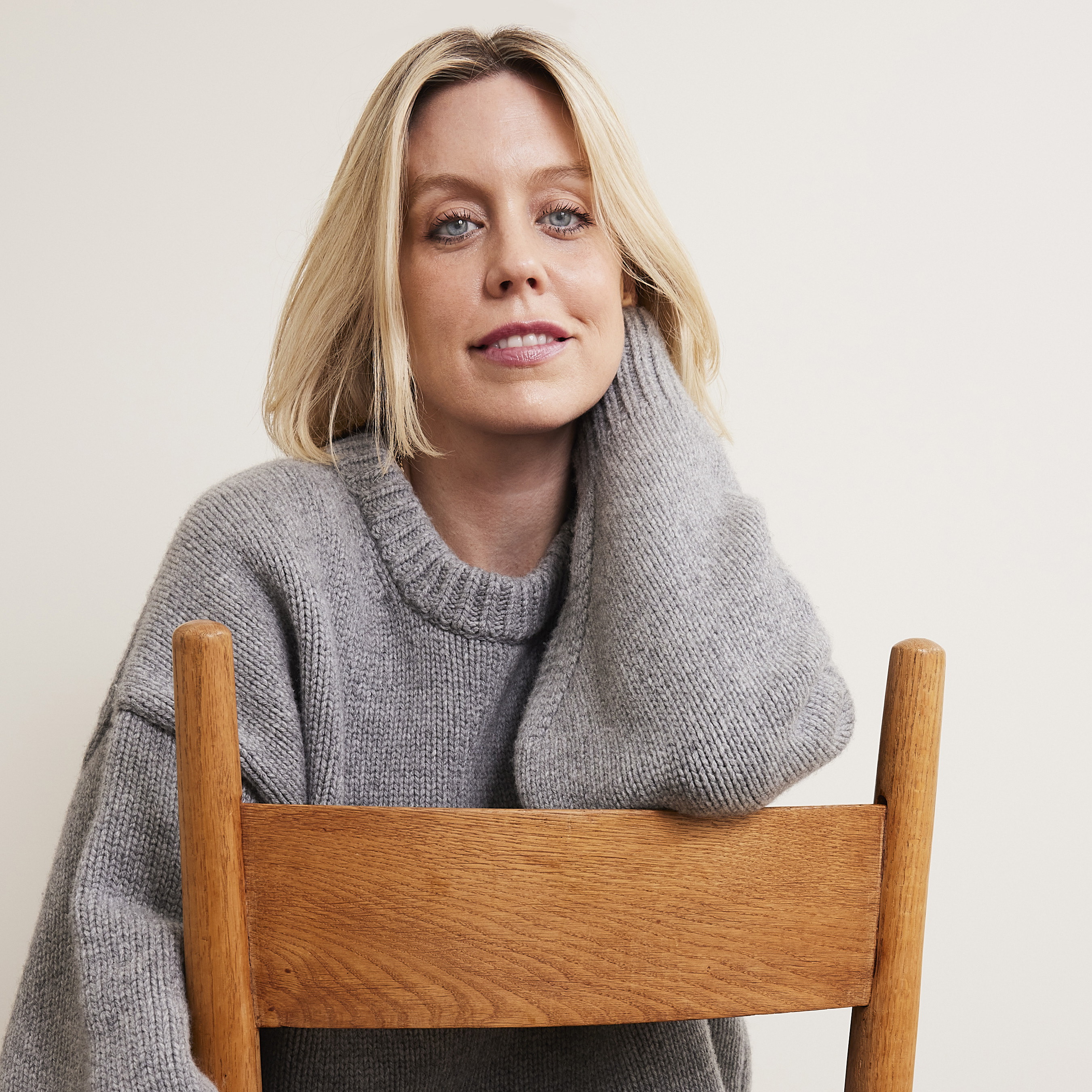 a woman sitting in a chair with her hand on her neck