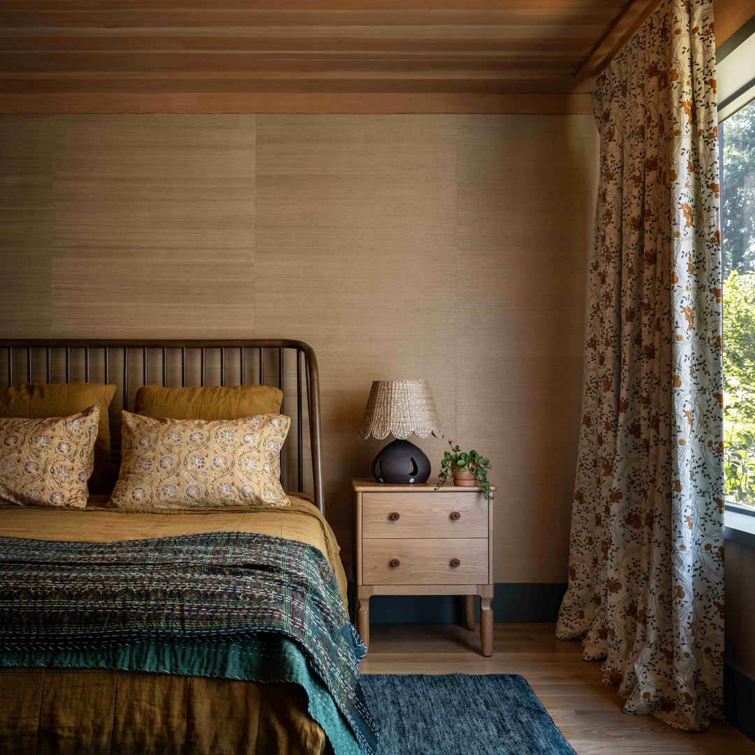 a bed sitting next to a window in a bedroom