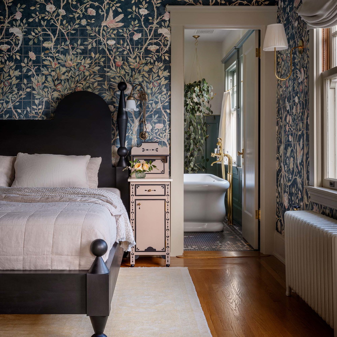 a bedroom with a bed, dresser, and bathtub