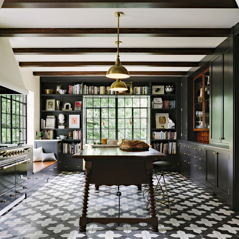 a room with a table, bookshelf, and a large window