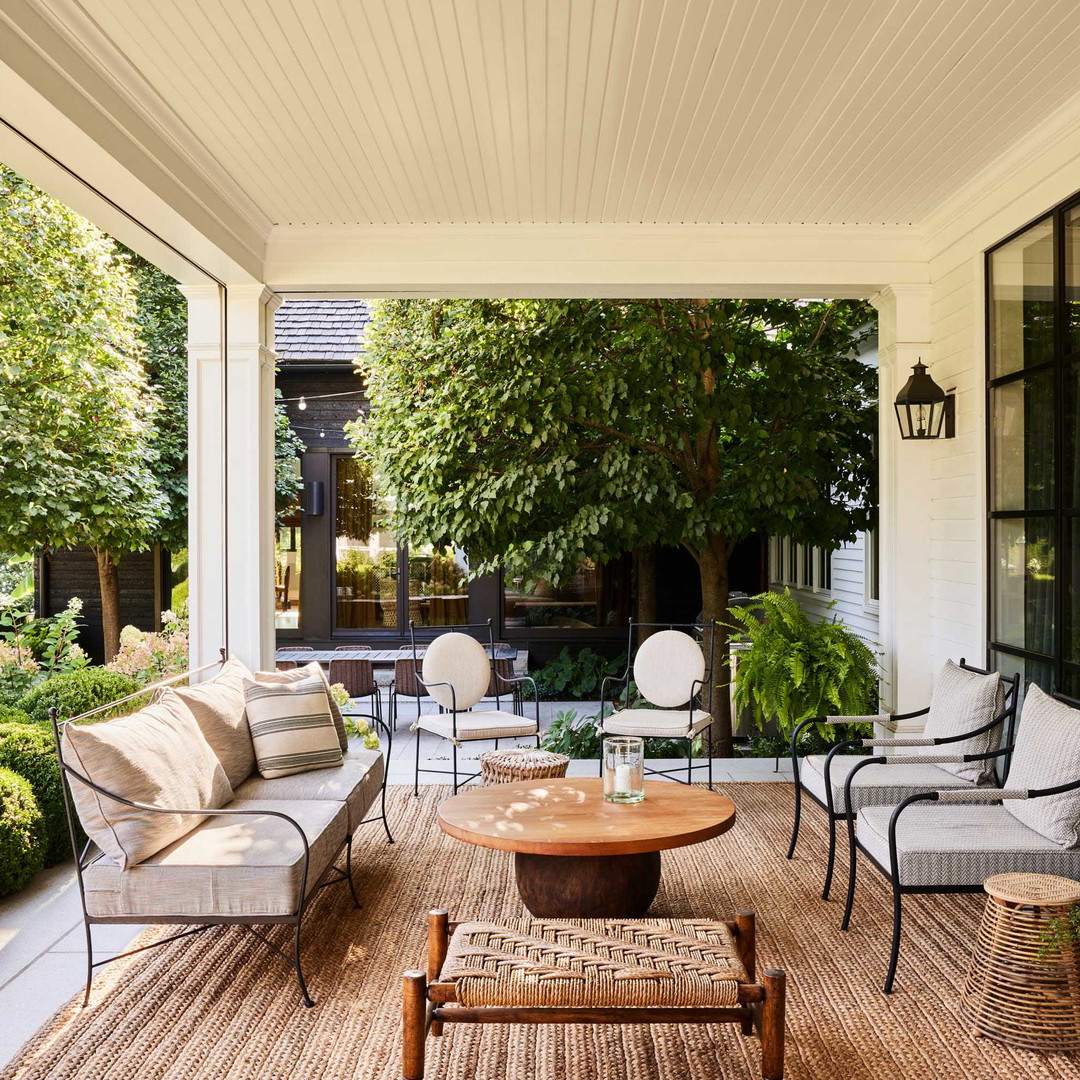 a covered porch with a table and chairs