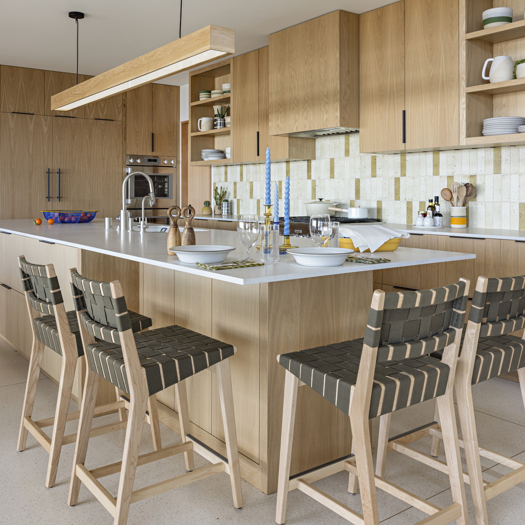 a kitchen with a center island with chairs around it