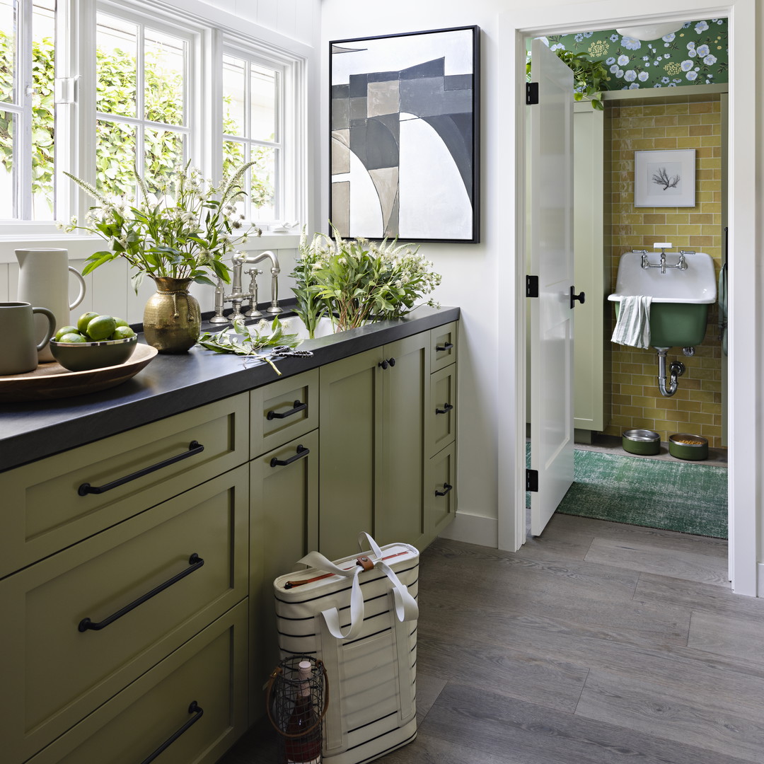 a kitchen with green cabinets and white walls