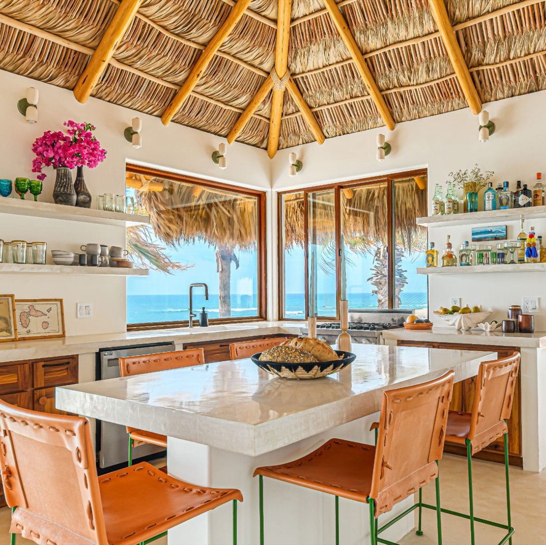 a kitchen with a large island with chairs around it