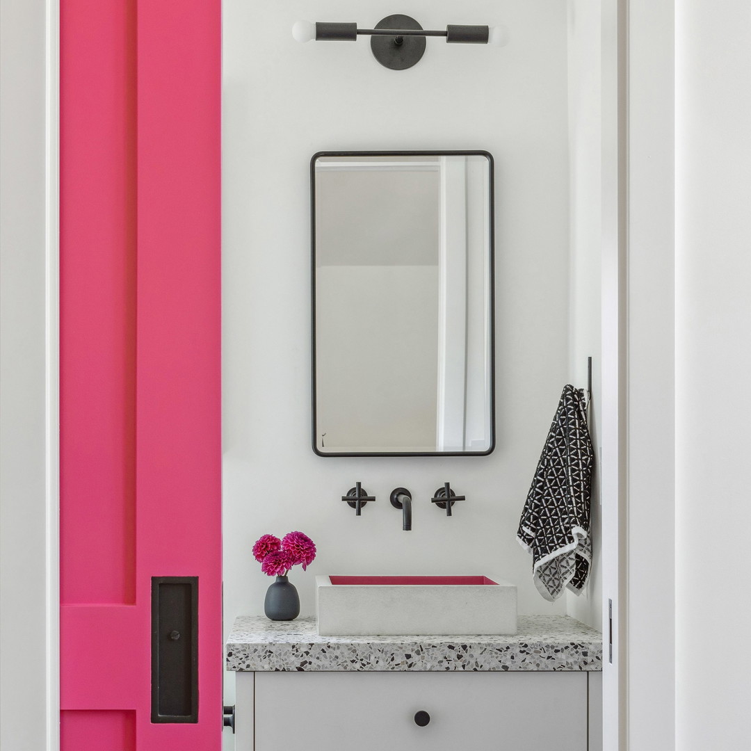 a bathroom with a pink door and a mirror