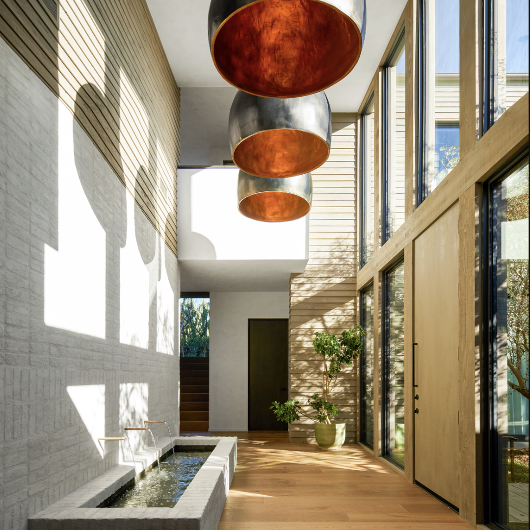 a hallway with a fountain and large windows