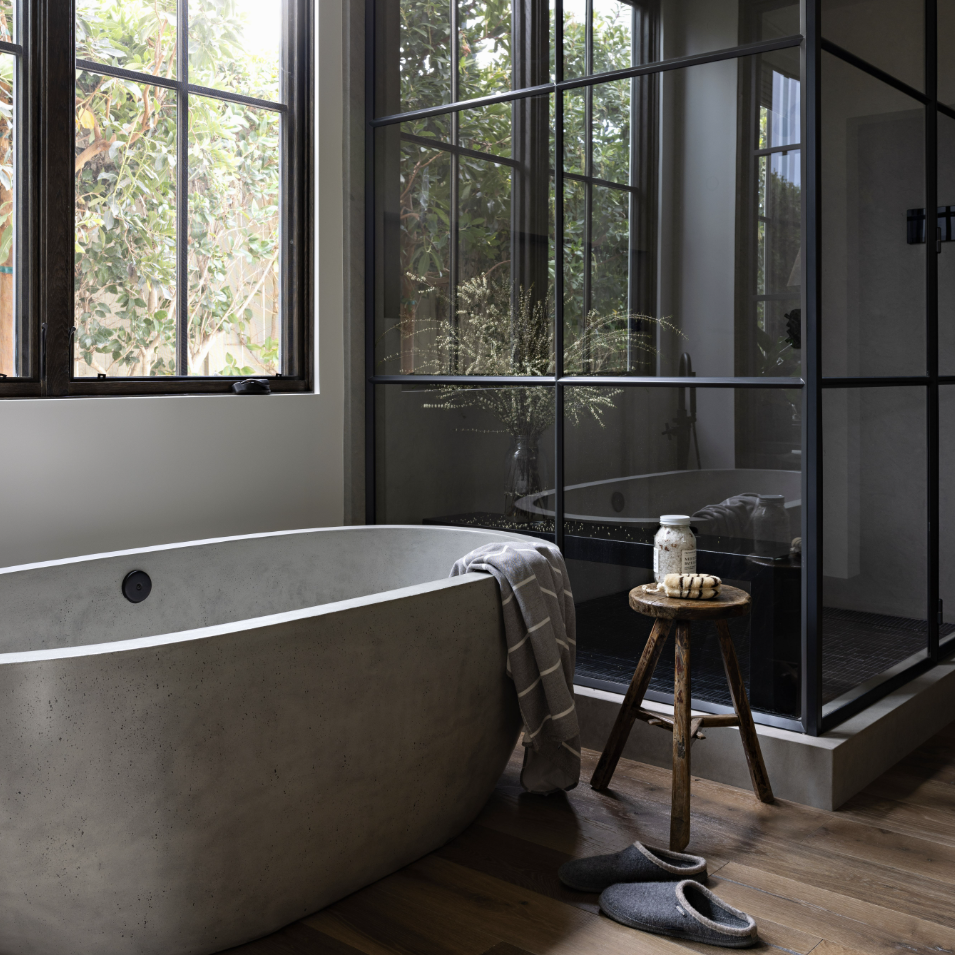 a bathroom with a large tub and a wooden floor