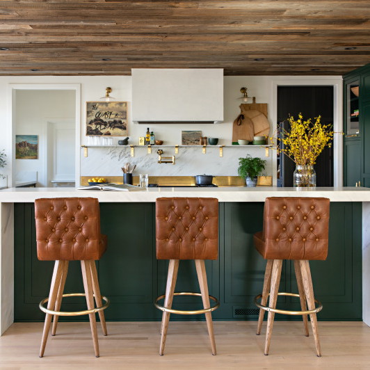 a kitchen with two stools and a center island